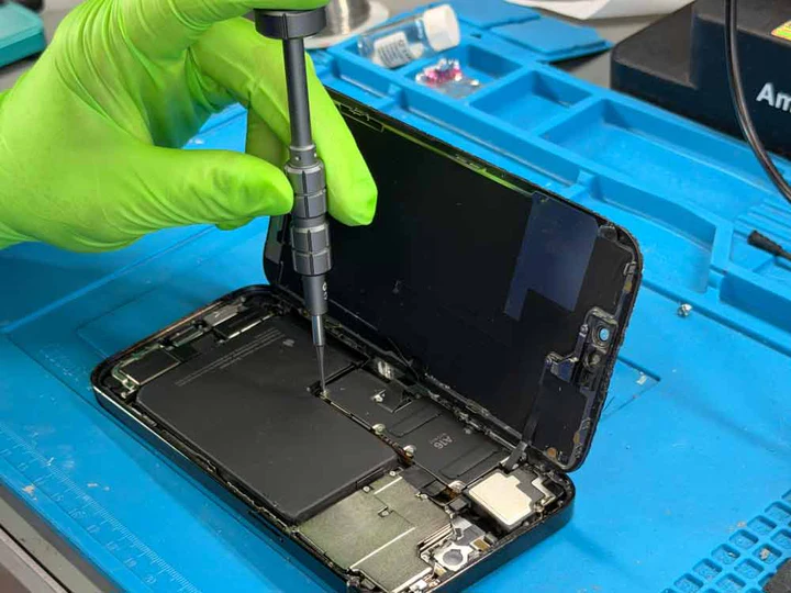Réparation iPhone ouvert carte mère gants verts